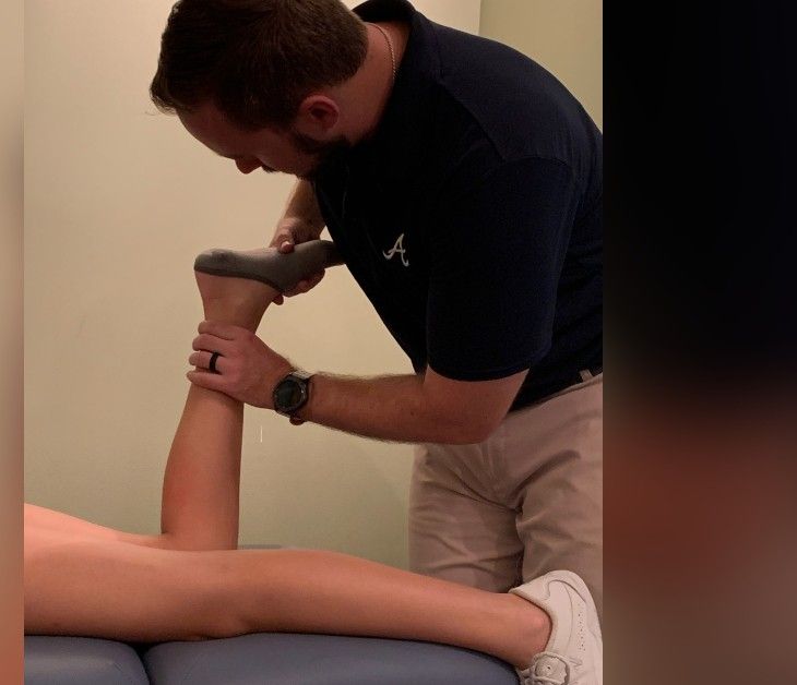 Dr. Strack performing a hands-on hamstring and leg release with a patient